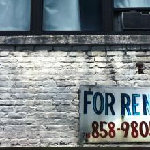 Brick wall and windwo with For Rent sign