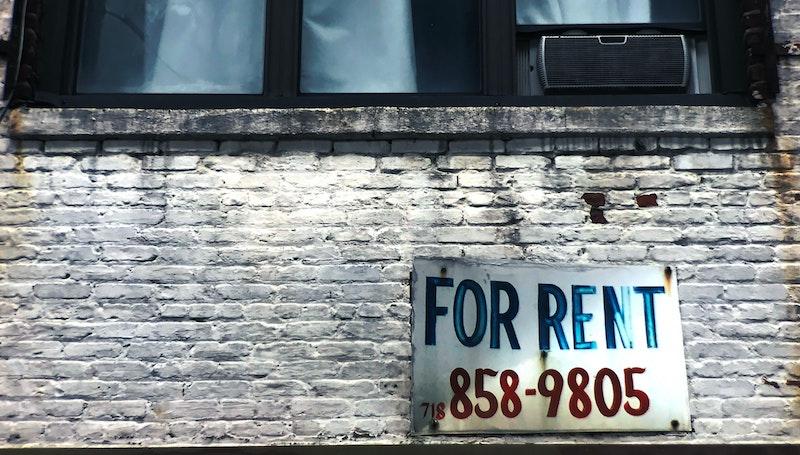 Brick wall and windwo with For Rent sign
