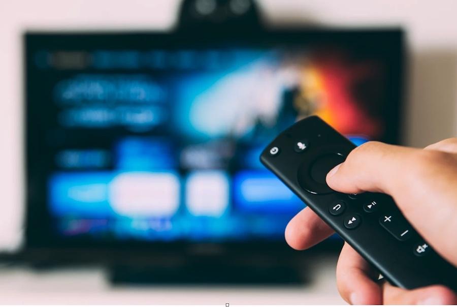 Smart TV and person's hand with remote