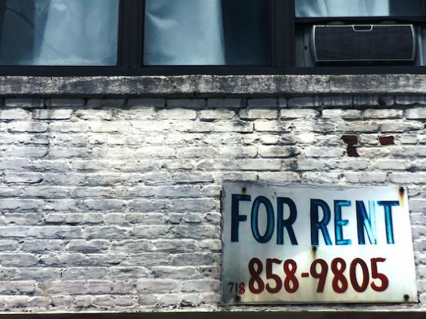 Brick wall and windwo with For Rent sign