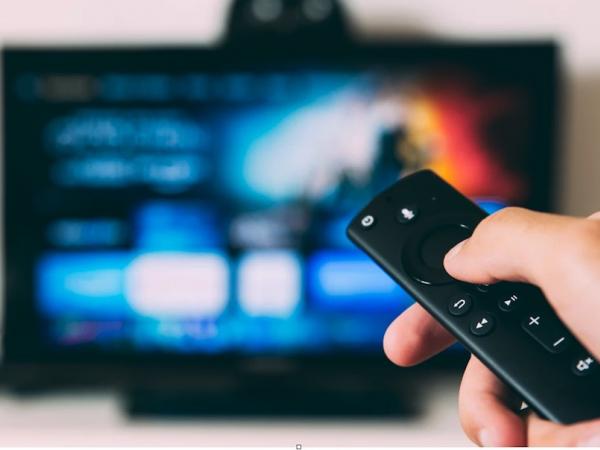 Smart TV and person's hand with remote